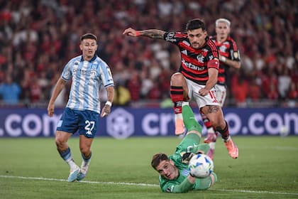 Con esfuerzo, Facundo Cambeses desbarata el peligro ante el uruguayo Giorgian de Arrascaeta; el arquero de Racing, figura de la Academia en el Maracaná