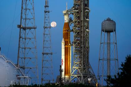 Con la Luna de fondo, el cohete del programa Artemisa de la NASA con la cápsula Orión en la parte superior
