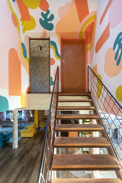 Con las mismas líneas abiertas de las barandas, Soqueff diseñó los cerramientos del pasillo que balconea al living.