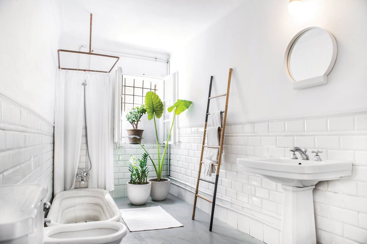 Con piso de cemento alisado y revestimiento de azulejos blancos, el baño tiene un lavatorio de pie que los chicos rescataron de una obra cuya iluminación realizaron.