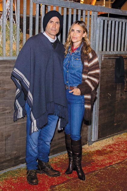 Con poncho, gorro tejido y borcegos, Adolfo le hizo frente a una jornada de frío y lloviznas. María, en tanto, lució look double denim, que acompañó con tapado tejido, pañuelo y botas de caña alta