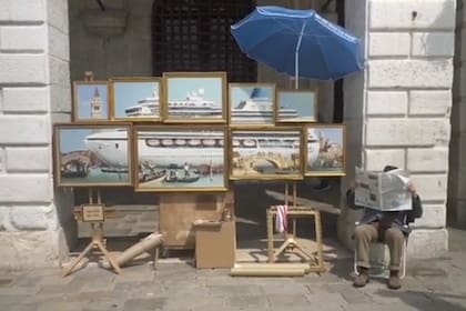 Con sombrero y detrás del diario, el artista sacó a la calle su denuncia al turismo masivo en Venecia
