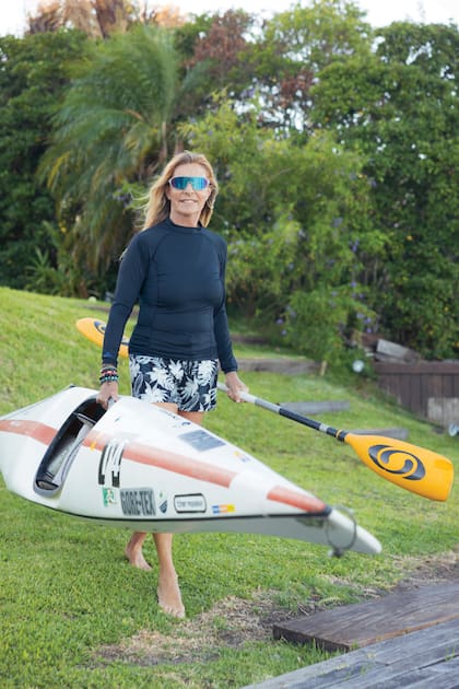 Con su equipo de agua, Virginia sale
a remar en su kayak por el lago que
está frente a su casa