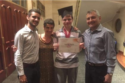 Con sus padres y su hermano el día en que recibió el título secundario, un logro cumplido con el apoyo de toda la familia.