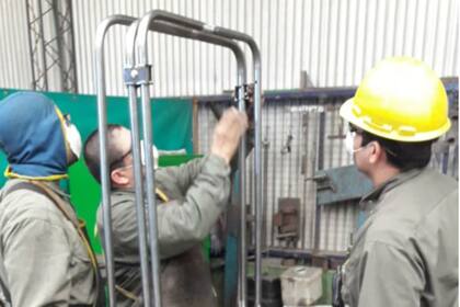Con todas las normas de seguridad por la pandemia, trabajadores ultiman detalles del biombo