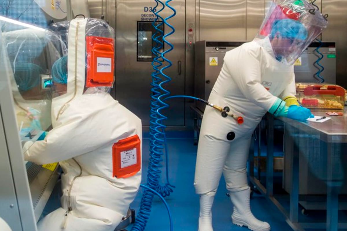 Con trajes especiales y protección, los trabajadores del laboratorio P4 de Wuhan trabajan junto a una jaula con ratones