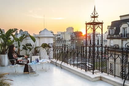 Con una vista impresionante a la ciudad, juego de mesa y sillas vintage con almohadones (Isadora).