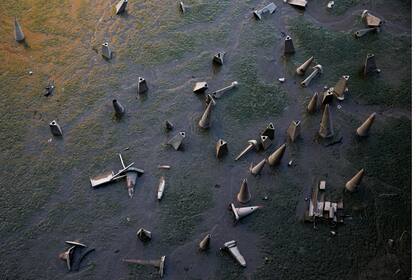 Conos de tráfico se ven en la orilla del río Támesis durante la marea baja