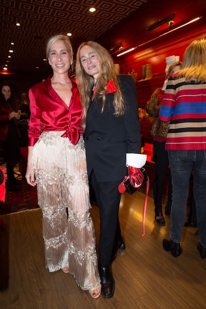 Constanza Di Cocco (dueña de TW Buenos Aires) se encargó del restyling de la tienda: la pintó toda de rojo y empapeló el techo con un diseño geométrico. Muy original, combinó un pantalón de flecos con una blusa satinada. En la imagen, junto a Delfina Vázquez Maiztegui, la pareja de Ramiro Agulla.