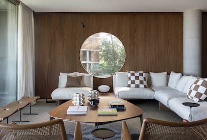 Contra la ventana, banco ‘Rosamaria Row’ (Bruno de Carvalho). Mesa de centro ‘Bank’ y sofá esquinero (todo de Sollos), con lámpara de mesa ‘Rituals 2’ (Foscarini). Cerámicas ‘Colección 60’, diseñadas por Cattarossi y realizadas por Adriana Abritta, de Arte Raku (El Camino Estudio)