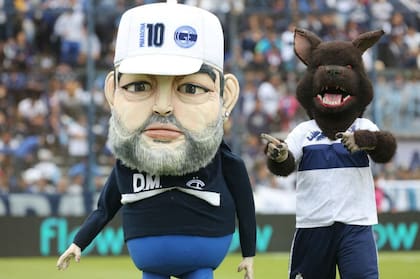El Maradona en formato muñeco, junto a la mascota de Gimnasia