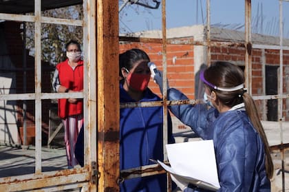 La médica Camila García toma la temperatura a una vecina en Villa Itatí