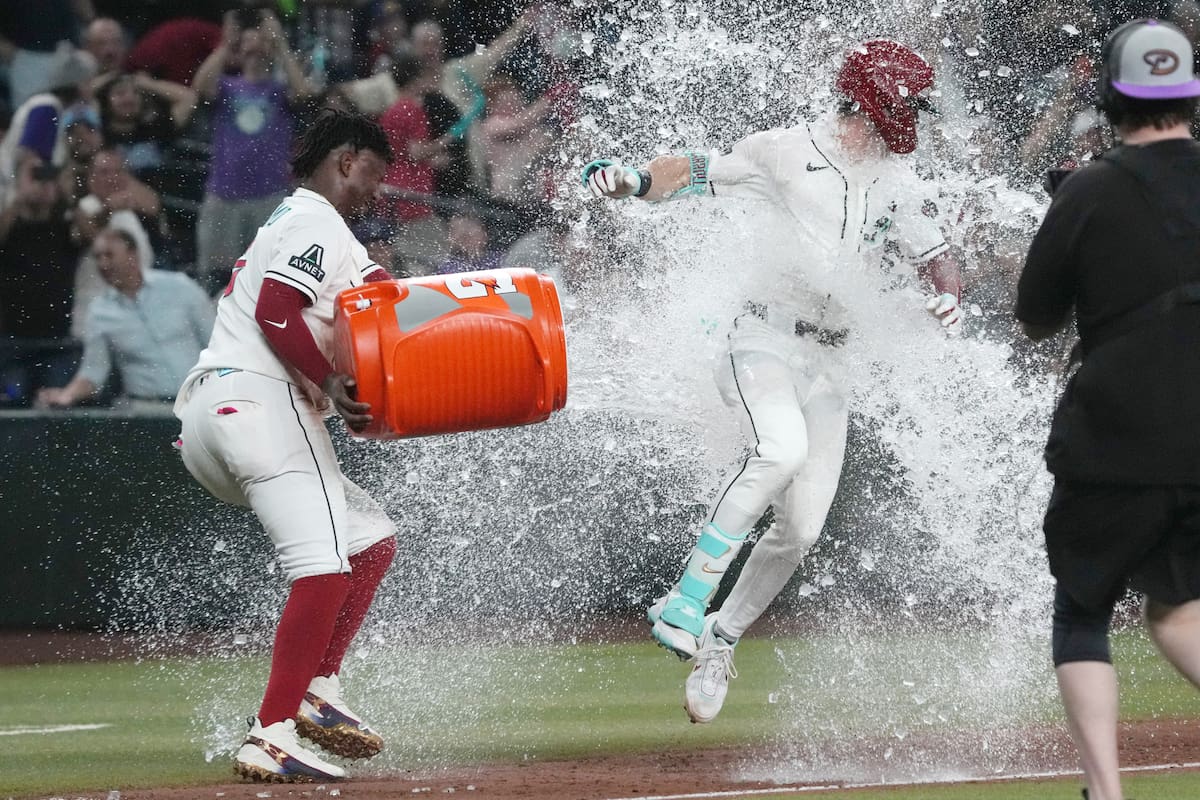 Corbin Carroll, derecha, de los Diamondbacks de Arizona, recibe un baño de Geraldo Perdomo después d