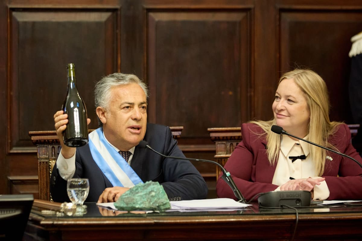 Cornejo levanta una botella de vino, junto a una roca con cobre, para asegurar que la minería y la vitivinicultura pueden convivir en Mendoza.