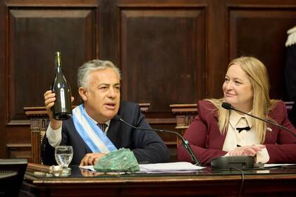 Cornejo levanta una botella de vino, junto a una roca con cobre, para asegurar que la minería y la vitivinicultura pueden convivir en Mendoza.