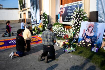 Los fieles rezan fuera de la Iglesia de la Candelaria, ya que permanece cerrada durante la Semana Santa en la Ciudad de Guatemala
