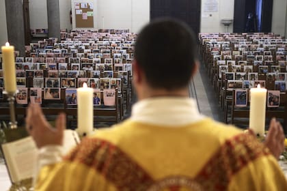 El sacerdote católico Georges Nicoli celebra una misa de Jueves Santo, transmitida en vivo en Facebook, con fotos de feligreses pegados a los bancos en la iglesia de Notre Dame De Lourdes en Bastía, en la isla mediterránea francesa de Córcega