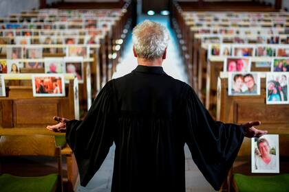 El pastor evangélico Klaus-Martin Pothmann de la iglesia de San Pankratius en Hamm, Alemania, brinda misa a la fotografía que su fieles le mandaron al no poder asistir a por cumplir la cuarentena