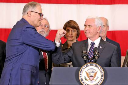 Mike Pence saluda al gobernador del estado de Washington, Jay Inslee, durante una conferencia de prensa sobre el coronavirus