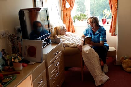 Coronavirus. Joan Loosley, de 100 años, habla con una enfermera en el hogar Fremantle Trust