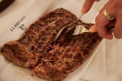 Corte con cuchara. La pestaña o tapa de ojo de bife como nueva tendencia en la parrilla. Preparación del plato que comía Maradona cuando iba a La Brigada. Retrato del dueño, Hugo, con el corte de carne.
12/08/2025.