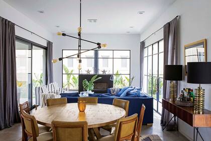 Cortinas de lino tamizan el sol de la tarde. Para la pared del hogar se hizo un cantero exterior donde las plantas harán lo propio, además de tapar las vistas.