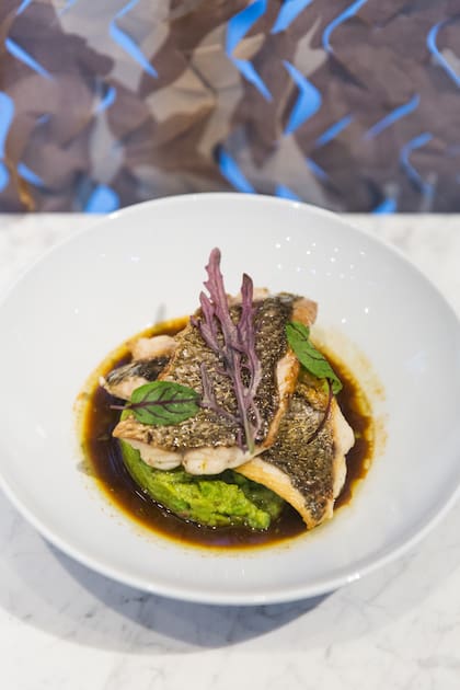 Corvina con caldo de escalivada y arvejas.