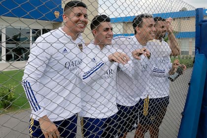 Cristian Pavón junto a sus compañeros de equipo mirando un partido de la reserva.