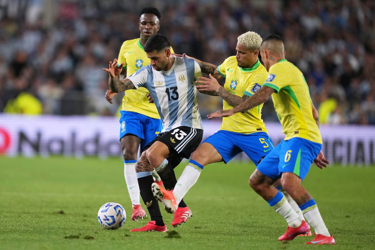 Cristian Romero, disputa la pelota con Joao Gomes (5) y Guilherme Arana (6) de Brasil durante un partido por las eliminatorias sudamericanas para el Mundial 2026 en Buenos Aires, Argentina, martes 25 marzo, 2025; el partido que generó un temblor en la Confederación Brasileña de Fútbol