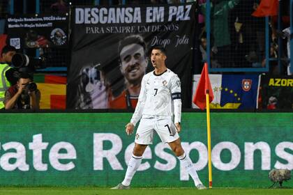 Cristiano Ronaldo celebra, con la bandera de Diogo Jota de fondo