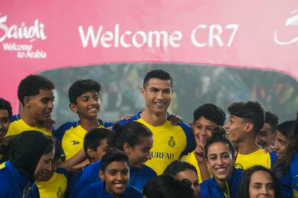 Cristiano Ronaldo sonríe, rodeado de chicos y chicas