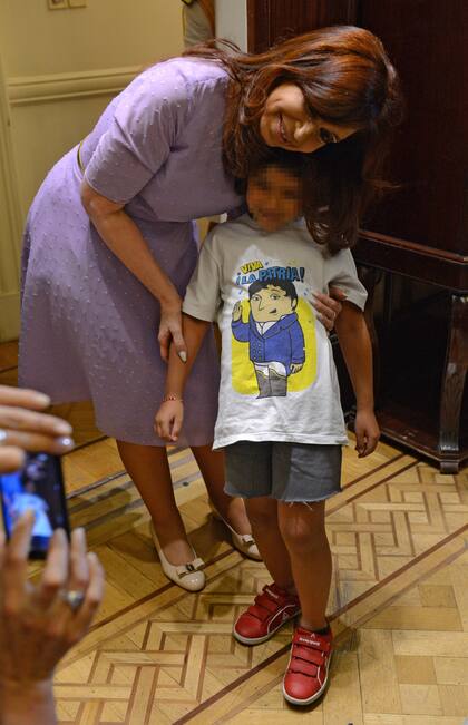 Cristina Kirchner durante un acto en la Casa Rosada, junto a una nena que usa una remera inspirada en La asombrosa excursión de Zamba