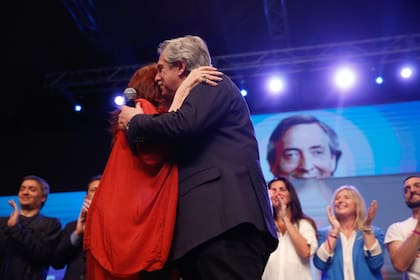 Cristina Kirchner y Alberto Fernández se abrazan tras conocer el resultado electoral, rodeados de dirigentes bonaerenses