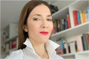 Cristina Pérez y la enorme biblioteca de su departamento de fondo