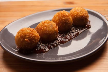 Croquetas de bondiola con chutney de tomate y semillas de sésamo en Bruta.