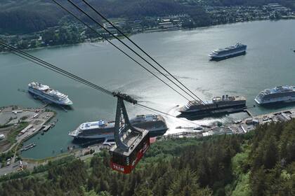Cruceros cerca del centro de Juneau el 7 de junio de 2023 junto al canal de Gastineau, Alaska. Miles de turistas llenan cada día un paseo marítimo en la capital de Alaska, desembarcando de los cruceros que se alzan sobre el centro urbano. Pero el cambio climático está derritiendo el glaciar Mendenhall, la principal atracción turística de Juneau. (AP Foto/Becky Bohrer)