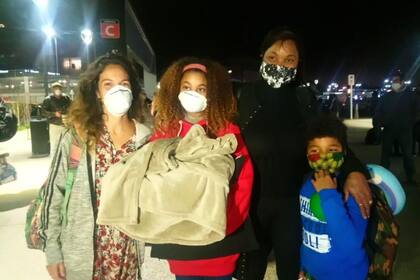 Crymy junto a sus hijos, Juliana y Ariel, que arribaron anoche a la Argentina desde Tanzania, junto a Maria Victoria Ballve Bengolea (izquierda), quien acompañó a los menores