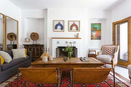Cuadros (Lola Erhart). Los sillones que tenían se mandaron a retapizar. La chimenea, simple, resultó el lugar ideal para colocar una serie de azulejos que los clientes habían comprado en un viaje al exterior.