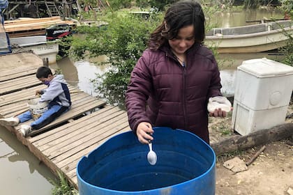 Cuando se quedan sin agua de los bidones que compran o les trae Aysa, la sacan directamente del río y le ponen sulfato de aluminio para que baje la tierra y después poner tomarla