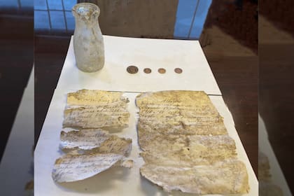 Cuatro monedas y dos cartas: el hallazgo inesperado adentro de una botella que data de más de un siglo