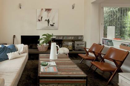 Cuero y madera, dos materiales infalibles reunidos en sillones de estilo nórdico, aportan diseño y calidez en este living de base clara
