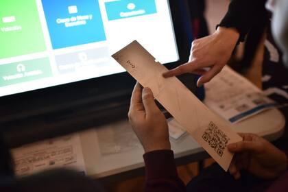 Curso de capacitación para autoridades de mesa para las próximas elecciones, simulación de la elección con máquinas de votar y el biombo con la urna y las boletas de papel