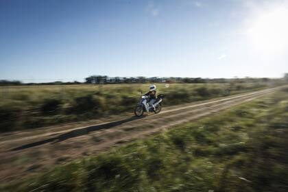 Cynthia recorre en su moto blanca la infinidad de caminos rurales, trazados como telaraña por el interior de los campos