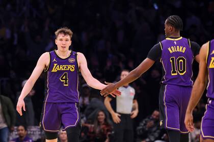 Dalton Knecht (izquierda) festeja con Christian Koloko, su compañero en los Lakers de Los Ángeles, luego de atinar un triple ante el Jazz de Utah, el martes 19 de noviembre de 2024 (AP Foto/Etienne Laurent)
