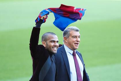 Dani Alves agita una camiseta de Barcelona junto al presidente del club, Joan Laporta, durante la presentación del lateral brasileño