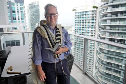 Daniel Gammerman posa para una fotografía en su balcón donde a veces reza mientras se prepara para celebrar en su casa las Fiestas Mayores judías, el jueves 26 de septiembre de 2024, en Miami. (AP Foto/Wilfredo Lee)