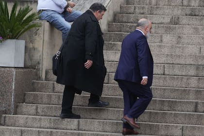 Daniel Garbellini (de negro) llega a los tribunales de Comodoro Py acompañado por su abogado, Agustín Biancardi