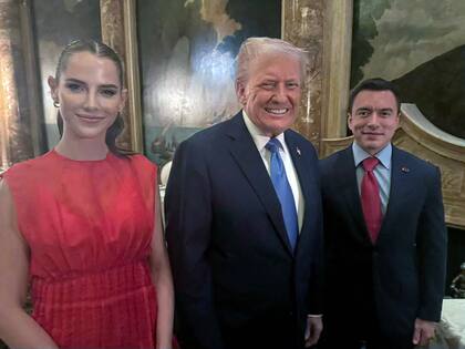Daniel Noboa y su esposa Lavinia Valbonesi posando para una foto con el presidente de Estados Unidos, Donald Trump, durante una reunión en un hotel de Florida
