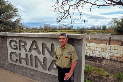 Daniel Rolando Guerra, presidente de la unión vecinal, junto al cartel que, en la entrada del pueblo, anuncia su nombre