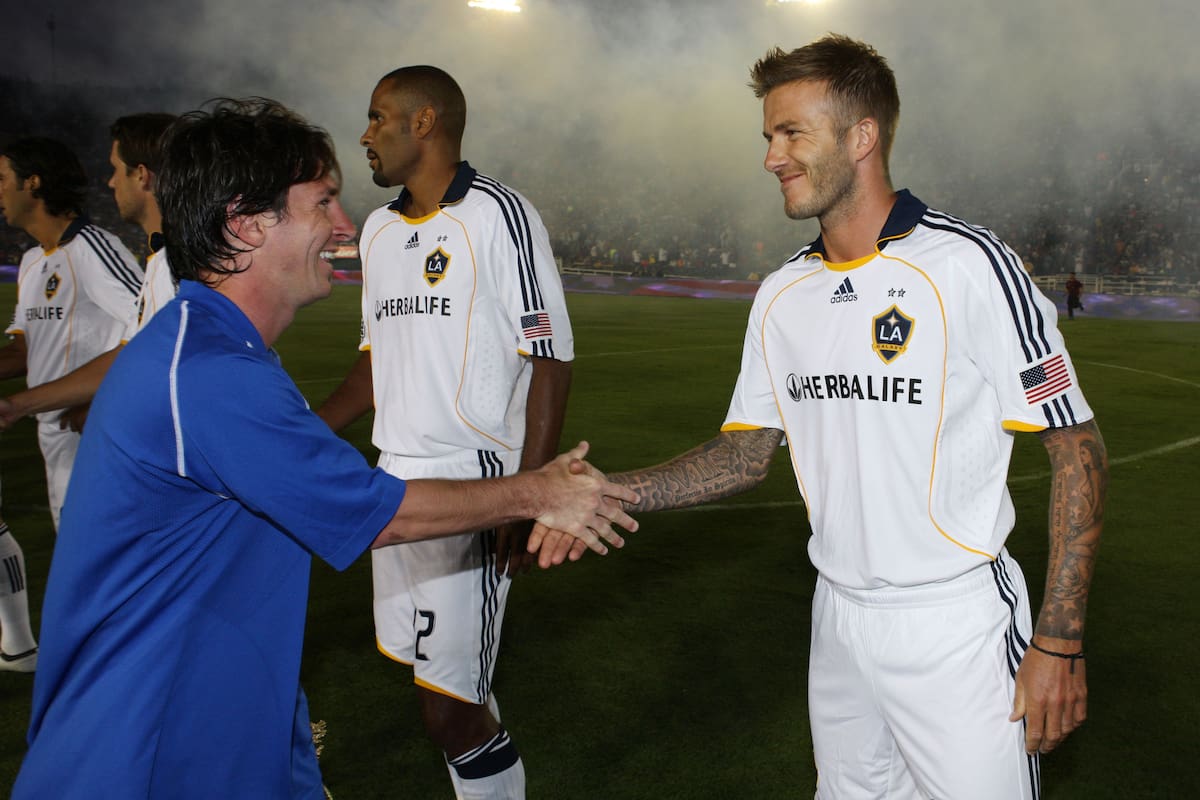 David Beckham y Lionel Messi se dan la mano en la previa de un amistoso entre Barclona y Los Ángeles Galaxy (Photo by Robert Mora/MLS via Getty Images)